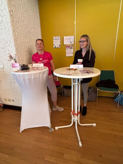 Zwei Mitwirkende an einem Stehtisch im Foyer vor gelber Wand. 4. Erzhäuser Gesundheits- & Pflegetag Erzhausen 2026.