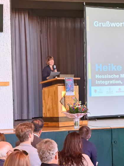 Grußwort von der Bühne, im Vordergrund die Köpfe des Publikums. 4. Erzhäuser Gesundheits- & Pflegetag Erzhausen 2026.