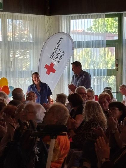 Publikum im Foyer, daneben die Fahne des Deutschen Roten Kreuzes. 4. Erzhäuser Gesundheits- & Pflegetag Erzhausen 2026.